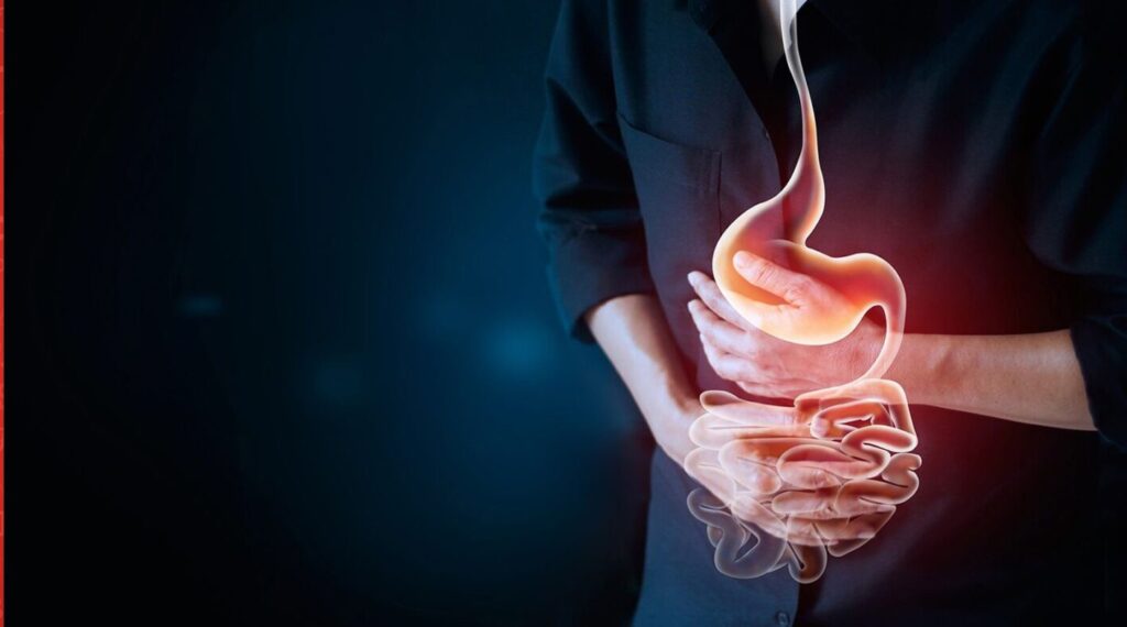 Image of person holding stomach with internal image of digestive system overlaid.