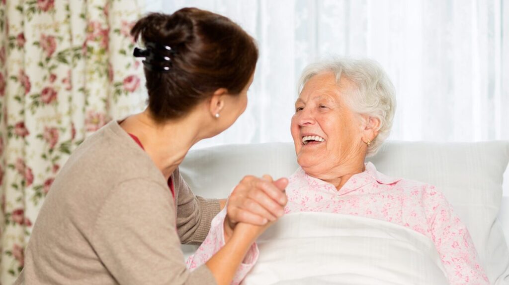 Image of person holding an elderly woman's hand.