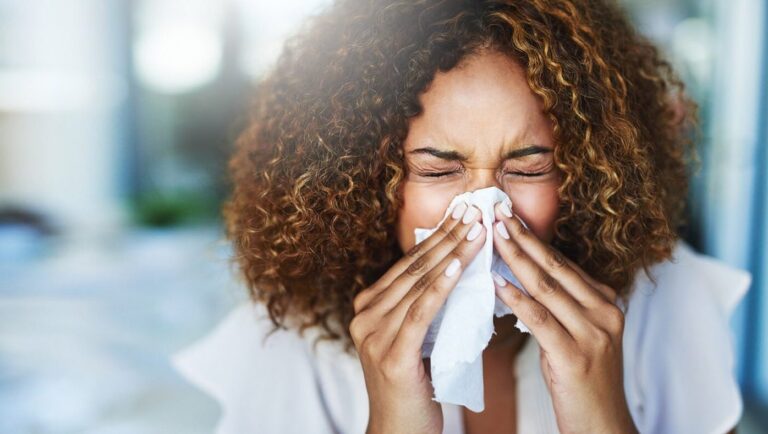 Image of woman sneezing.