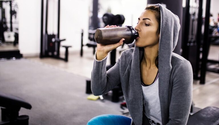 Image of woman drinking a protein shake at the gym.