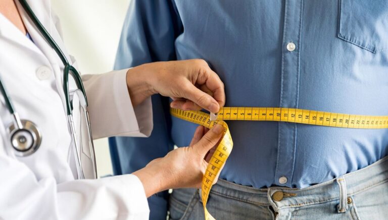 Image of doctor measuring a person's waist with a temperature.